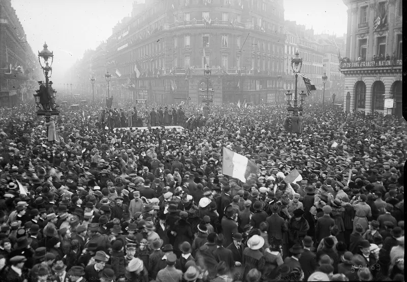Photographie : une foule immense, drapeaux tricolores levés, emplit la place de l’Opéra