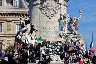 Des manifestants massés sur le monument à la République, autour d'une banderole noire : « La répression n'arrêtera pas notre révolte !! »