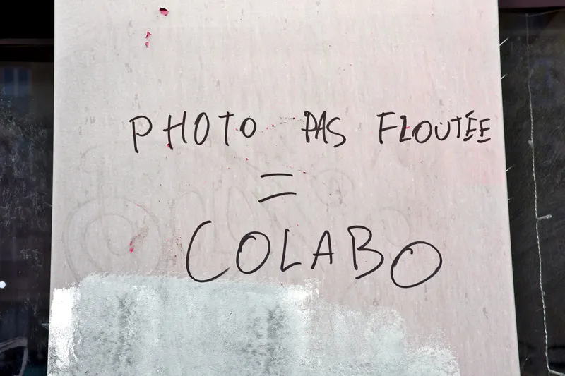 Inscription au feutre sur un panneau blanc : « Photo pas floutée = colabo »