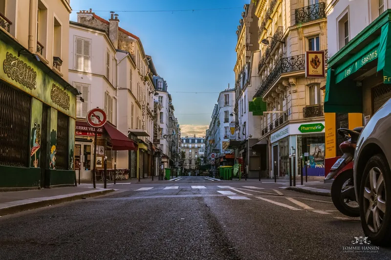 Photographie : la rue Daguerre vue en enfilade au petit matin, chaussée vide, devantures et immeubles de part et d'autre