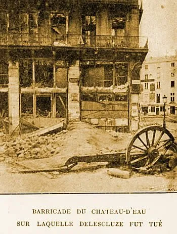 Photographie : une maison dévastée, au rez-de-chaussée éventré, et un affût de canon renversé sur les pavés