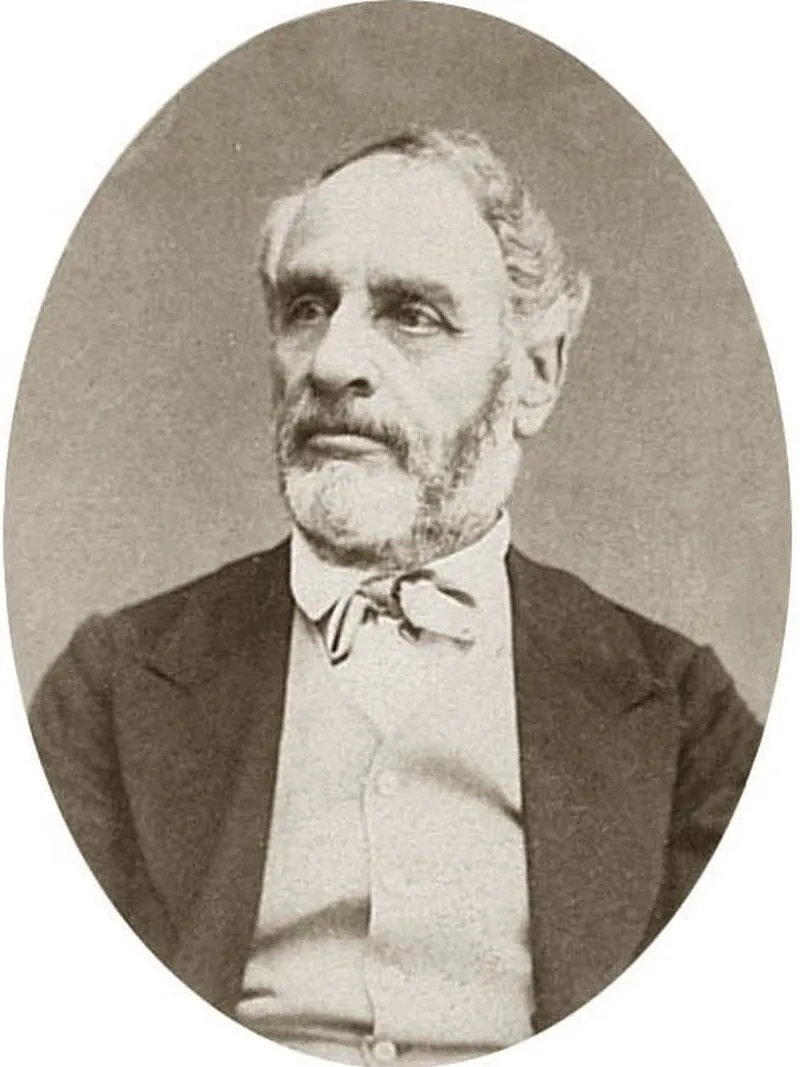 Photographie en médaillon : portrait d’un homme âgé à barbe blanche, en redingote