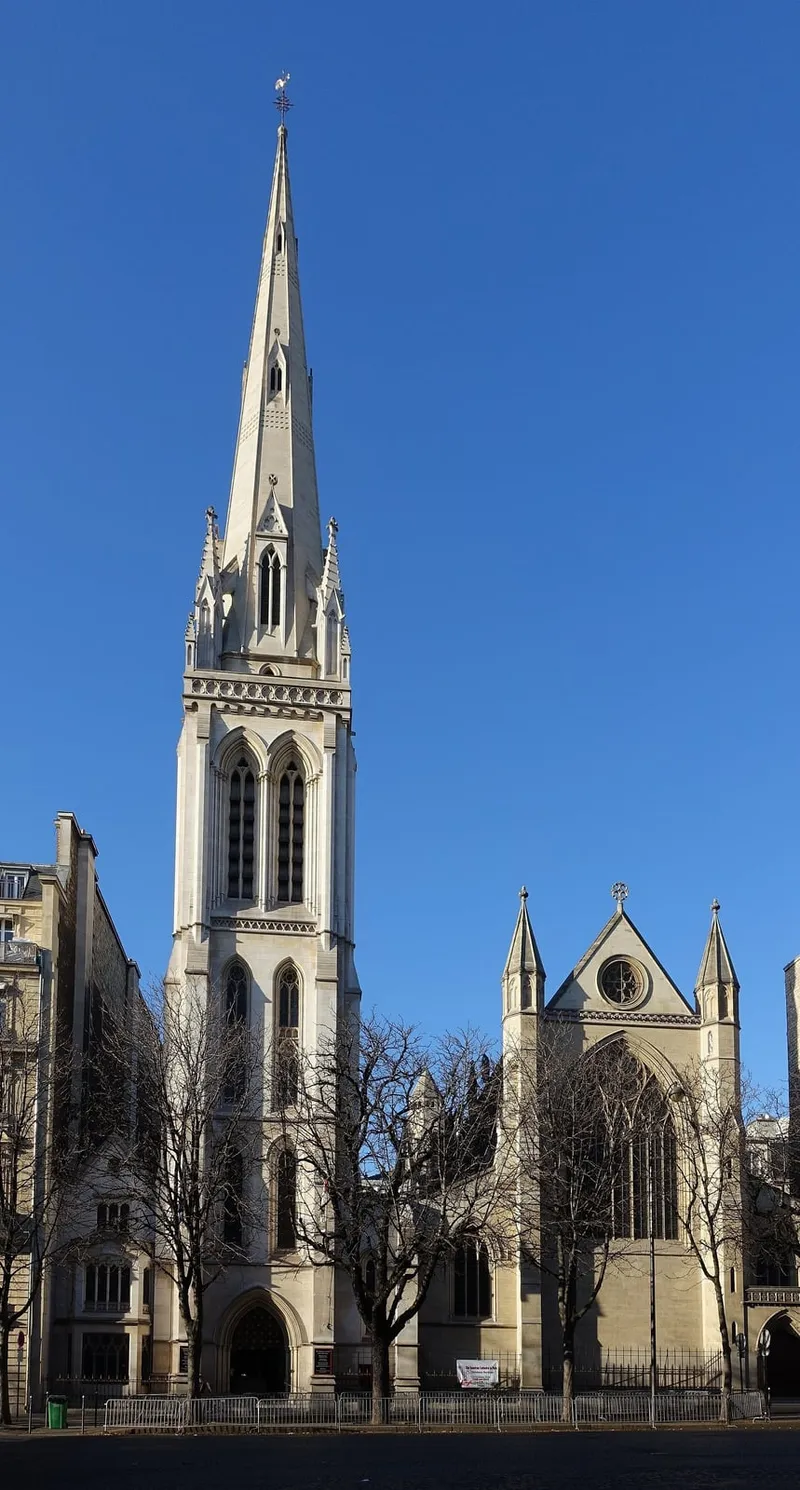 Photographie : la haute flèche gothique de la cathédrale, au-dessus de ses toits