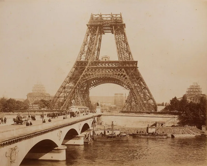 Photographie : la tour Eiffel arrivée au deuxième étage, le pont d'Iéna et des bateaux sur la Seine