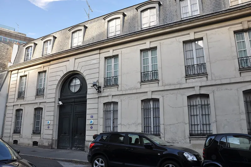 Photographie : la façade d'un hôtel particulier de pierre, avec une haute porte cochère cintrée
