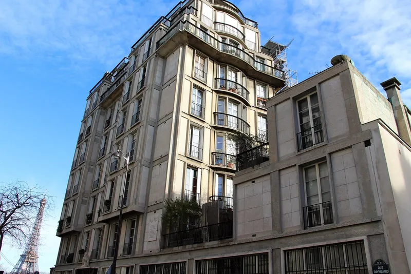 Photographie : un immeuble de béton à bow-windows, à l'angle d'une rue