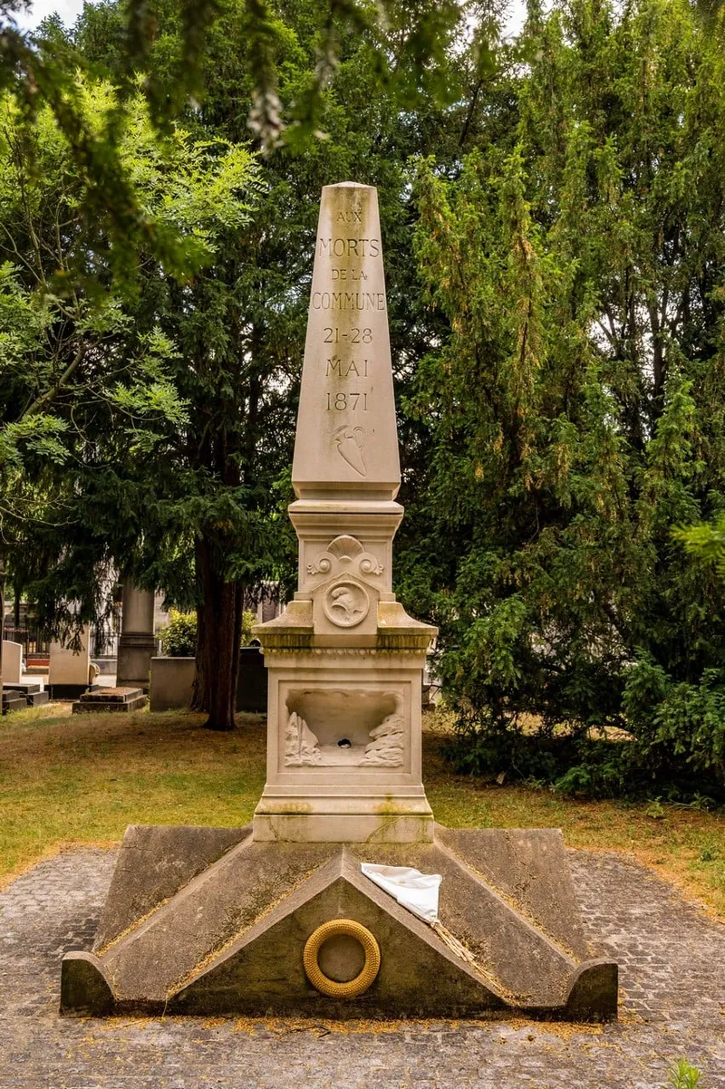 Photographie : le monument aux fédérés, un obélisque entre les arbres du cimetière du Montparnasse