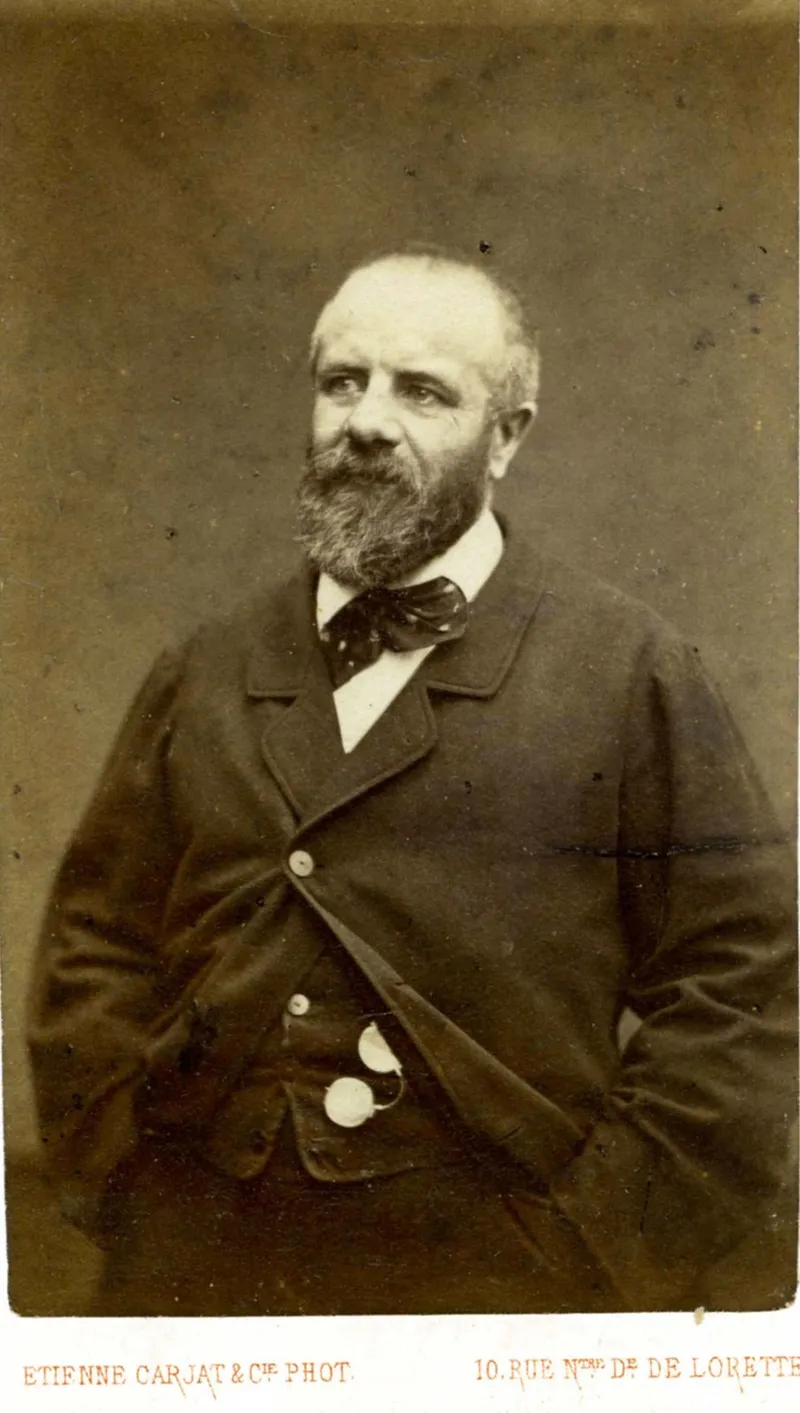 Photographie ancienne : Eugène Pottier debout, de trois quarts, barbe et cheveux blancs, en veste sombre et nœud lavallière, une main dans la poche