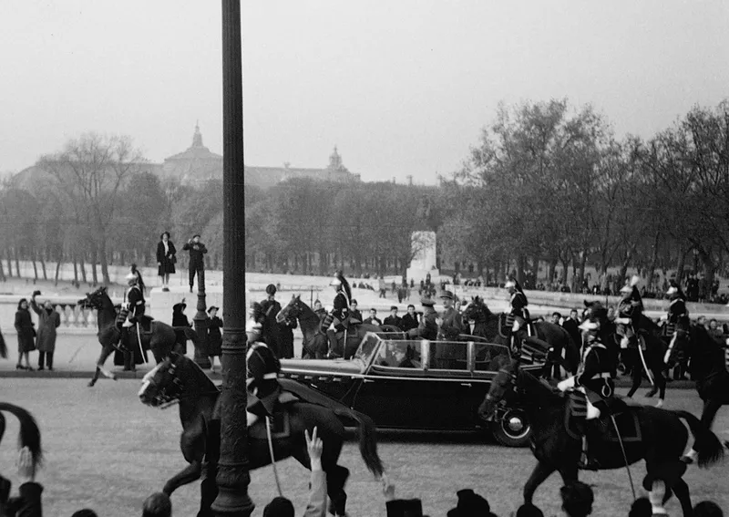 Photographie : place de la Concorde, une voiture découverte escortée de cavaliers de la Garde, devant une foule massée sous un ciel gris