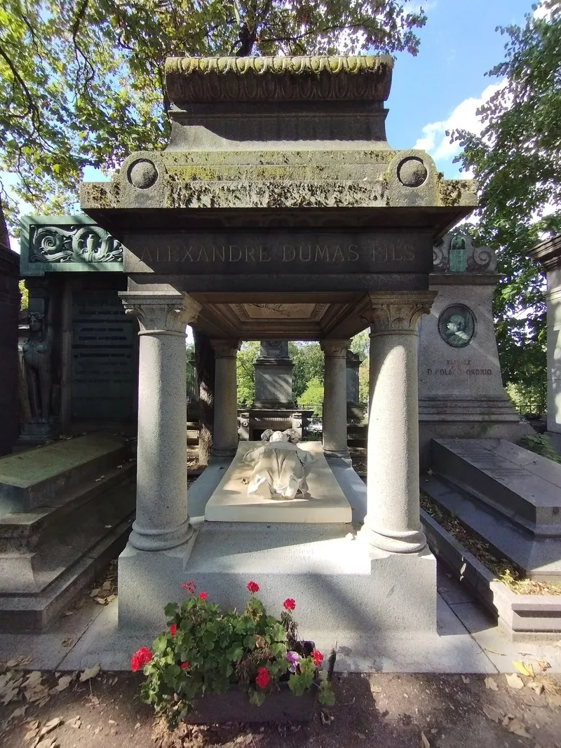 Photographie : la tombe d'Alexandre Dumas fils, gisant sous un dais de pierre à colonnes