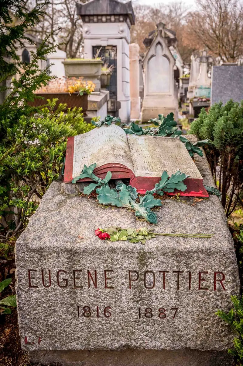 Photographie : un livre ouvert sculpté, couvert de feuilles de chêne, sur la tombe gravée « Eugène Pottier »