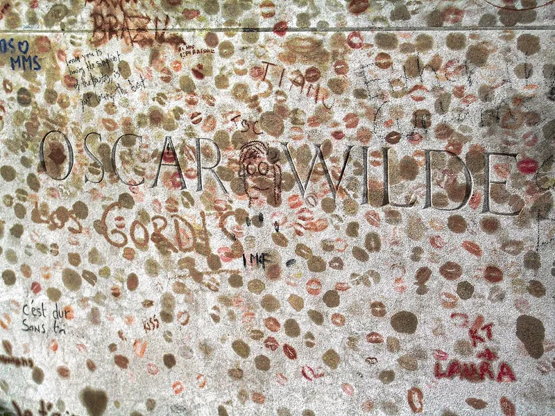 Photographie : le nom d'Oscar Wilde gravé sur son tombeau, couvert de traces de rouge à lèvres