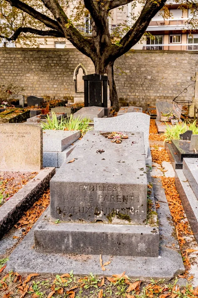 Photographie : la dalle gravée « Familles Ulysse Parent, Bayeux-Dumesnil », au pied du mur du cimetière de Montmartre