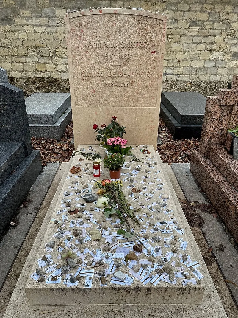 Photographie : la tombe de Jean-Paul Sartre et Simone de Beauvoir, couverte de billets et de fleurs