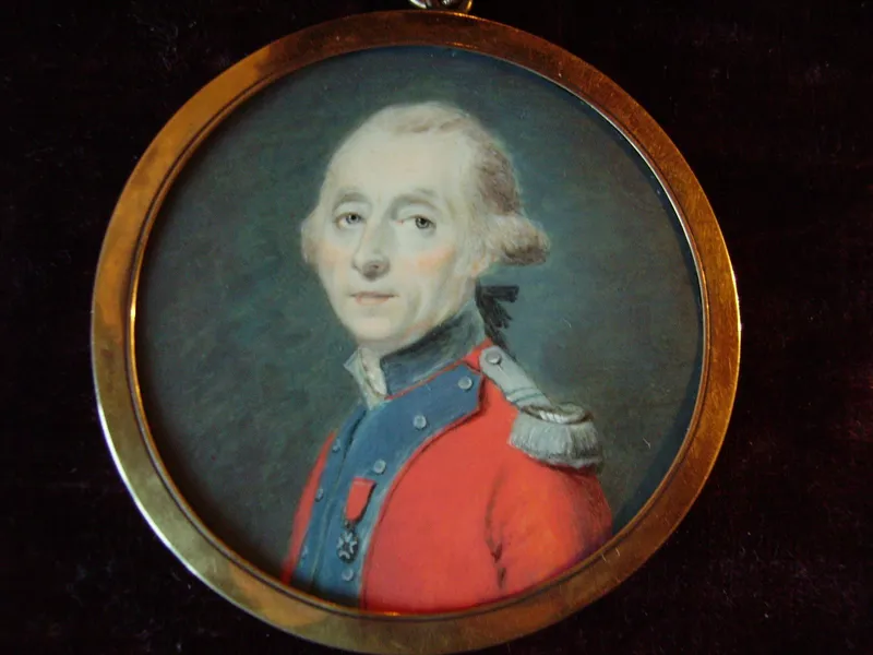 Portrait en miniature, dans un cadre rond doré : un homme aux cheveux poudrés, en habit rouge à revers bleus